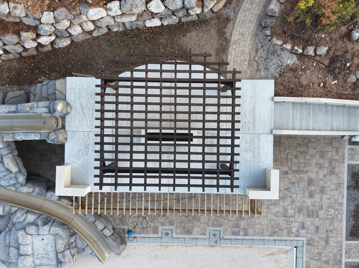 The Cordovan Brown 18×18 pergola from straight above, on the roof deck over a covered pool in Elk Ridge, Utah